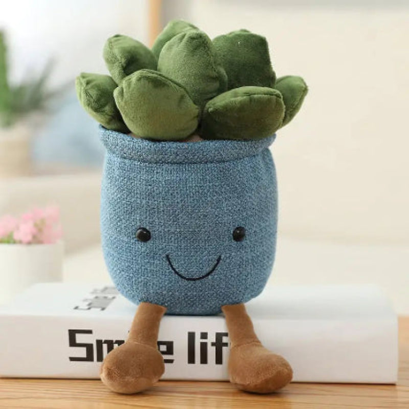 Plush toy plant with a blue pot and smiling face on a wooden surface.