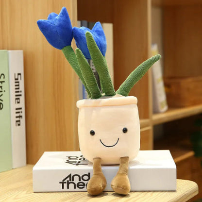 Plush toy plant with blue flowers and a smiling face on a wooden surface.