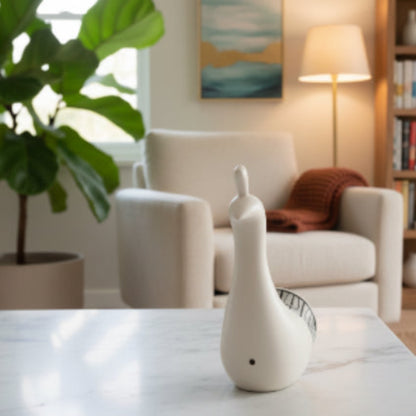 White ceramic goose on a marble surface.